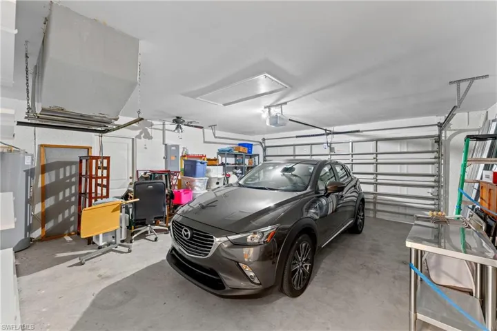 Garage with water heater, ceiling fan, and electric panel