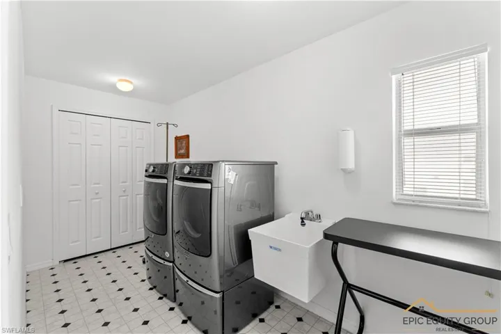 Laundry room with light floors and washer and dryer