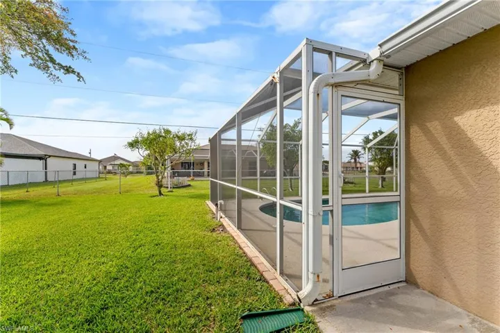 Fenced backyard featuring an outdoor pool, glass enclosure, a sunroom, and a patio
