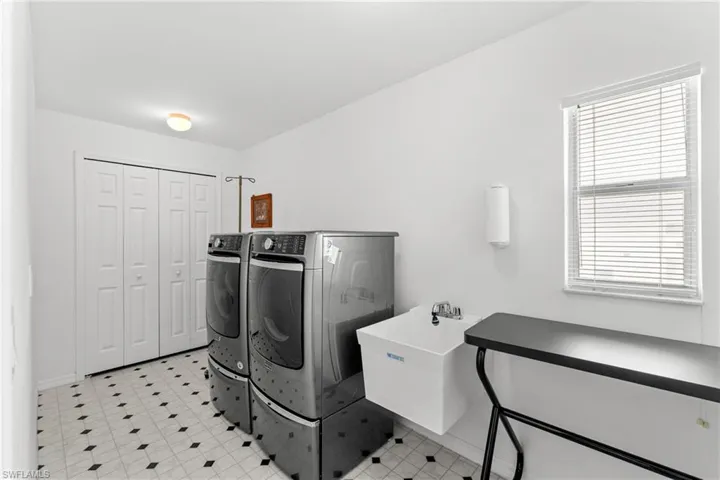 Laundry room with light flooring and washer and clothes dryer