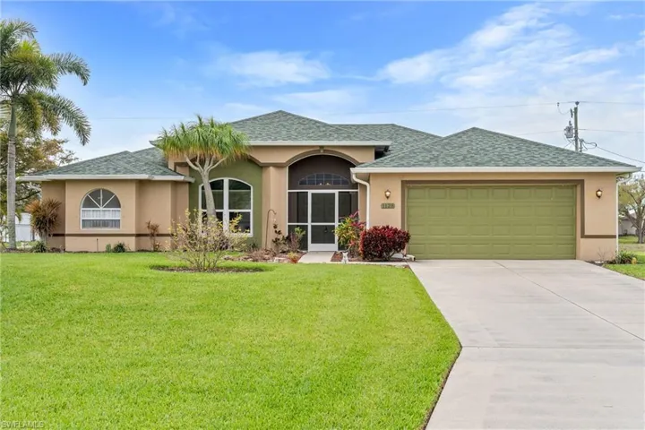 Single story home with stucco siding, roof with shingles, a garage, a sunroom, and driveway