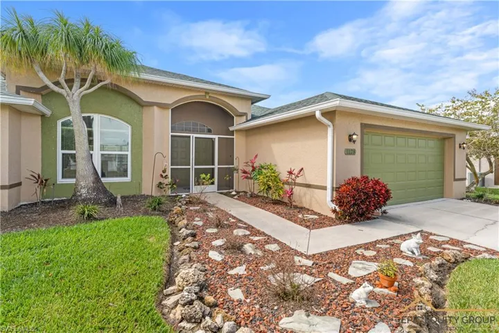 Ranch-style home with stucco siding, an attached garage, a sunroom, and concrete driveway