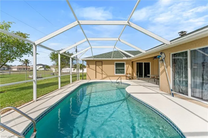 Outdoor pool featuring a sunroom, a lanai, and a patio