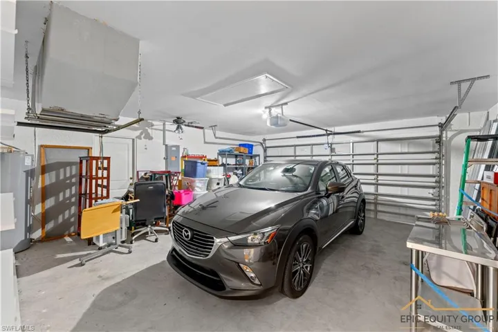 Garage with water heater, ceiling fan, and electric panel