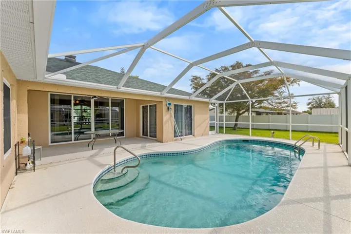 View of swimming pool with a sunroom, patio surround, and glass enclosure