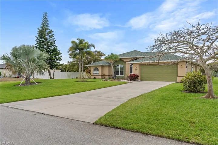 View of front of property featuring stucco siding, an attached garage, and concrete driveway