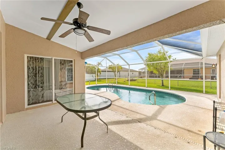 View of swimming pool featuring patio surround, a sunroom, and a lanai