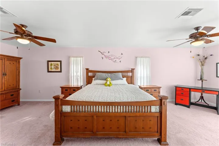 Carpeted bedroom featuring ceiling fan