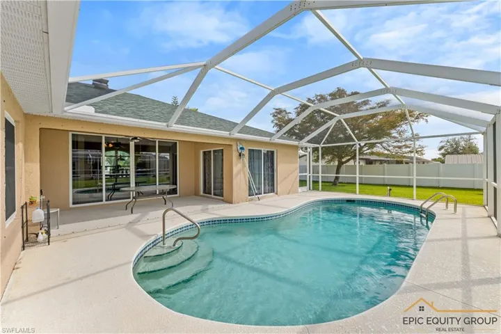 View of swimming pool featuring a sunroom, patio surround, and glass enclosure