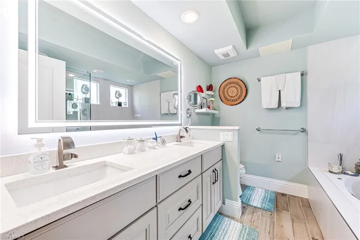 Master Bathroom with dual sinks, glass enclosed shower and separate jetted tub