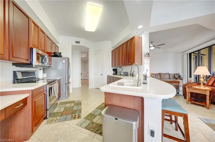 Kitchen featuring appliances with stainless steel finishes, a breakfast bar, light countertops, a peninsula, and recessed lighting