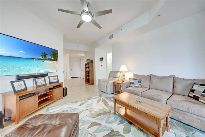 Living room featuring light tile patterned floors and a ceiling fan
