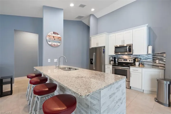 Kitchen featuring stainless steel appliances, granite counter tops and counter bar seating for 4