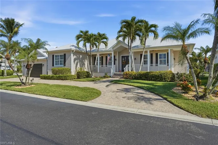 Single story home featuring decorative driveway, a porch, and a front lawn