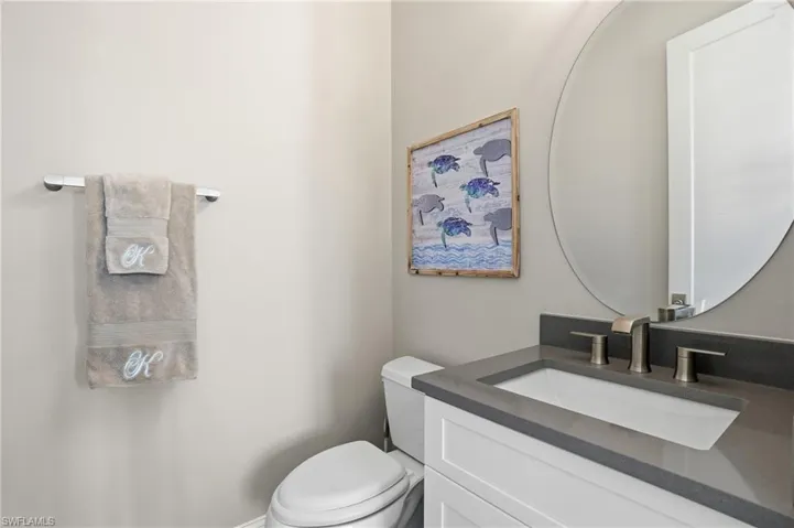 Half bathroom featuring vanity and toilet