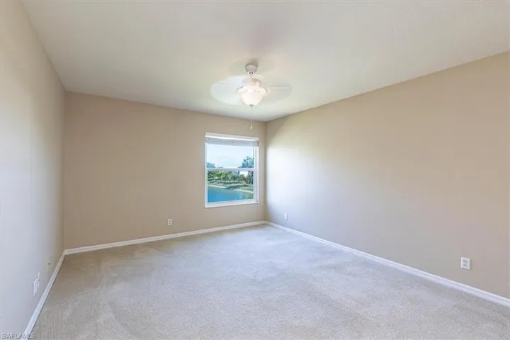 Room featuring light colored carpet & ceiling fan.