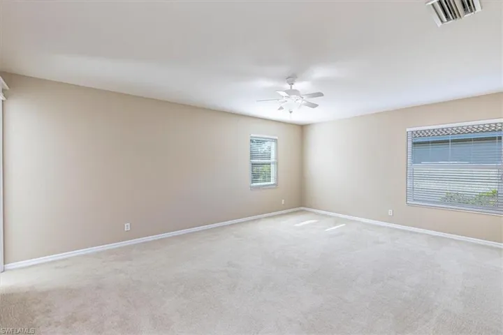 Room featuring light colored carpet & ceiling fan.