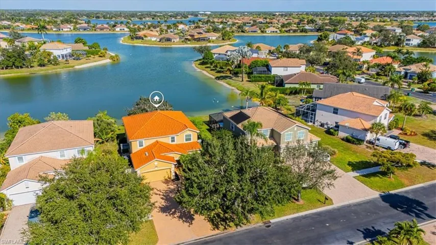 Aerial perspective of the front of the home and lake.