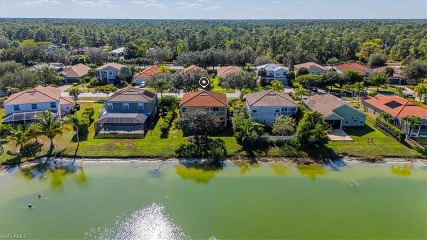 Aerial perspective of the rear of the home and lake.