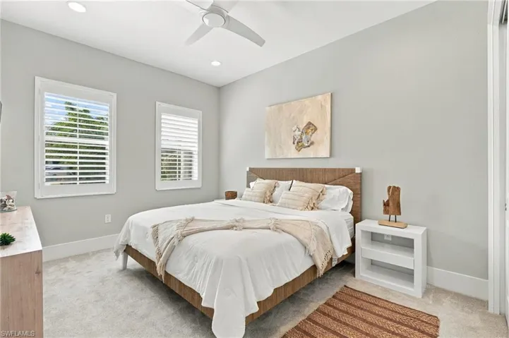 Bedroom featuring neutral carpeting, white plantation shutters, recessed lighting, and a modern ceiling fan