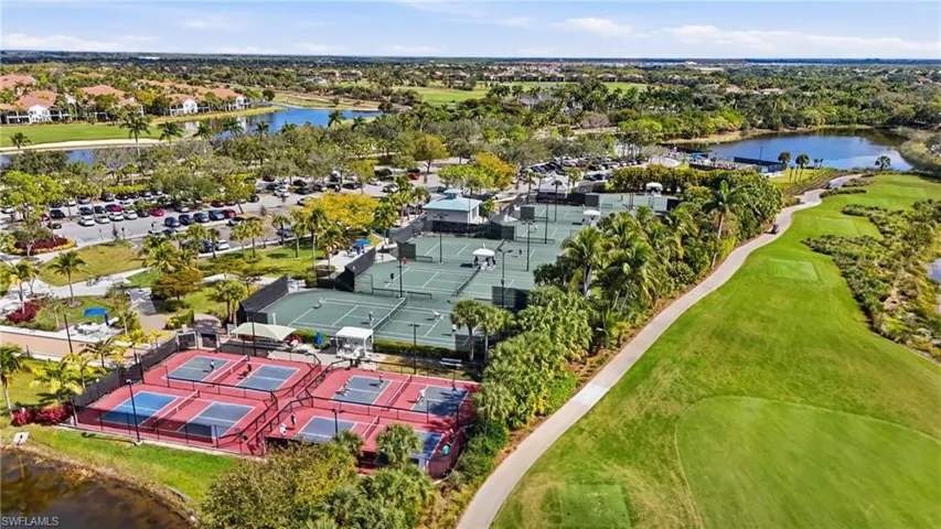 Aerial view of recreational amenities including multiple fenced tennis courts, four pickleball courts, and expansive landscaped grounds with integrated golf course fairways