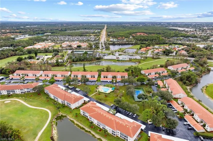 Aerial view of residential area with a golf club and a large body of water
