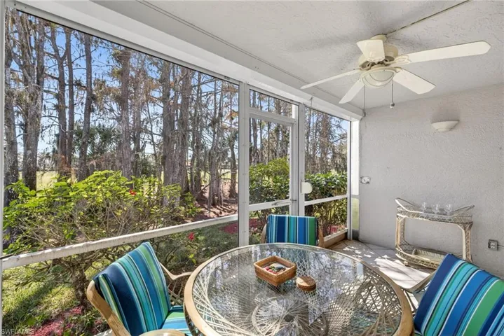 Sunroom / solarium with outdoor dining area and ceiling fan
