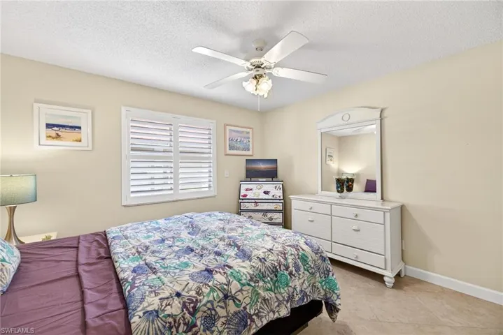 Bedroom featuring a ceiling fan and a textured ceiling