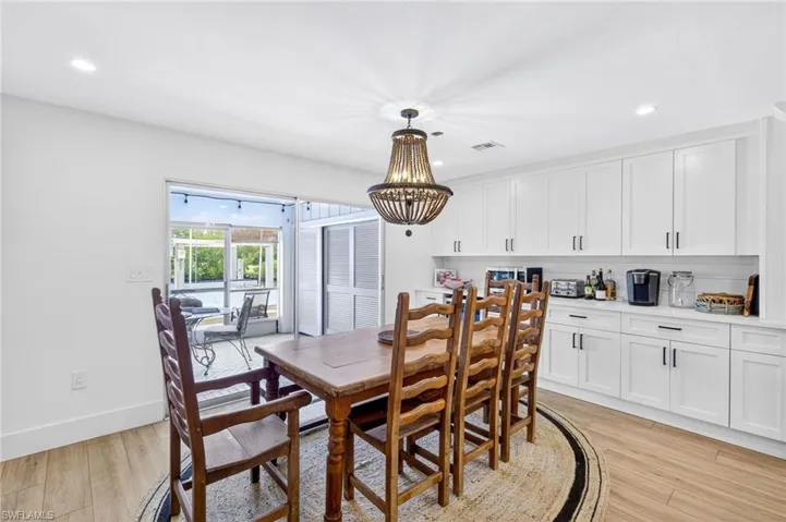 Dining space with light wood-type flooring, a chandelier, and recessed lighting