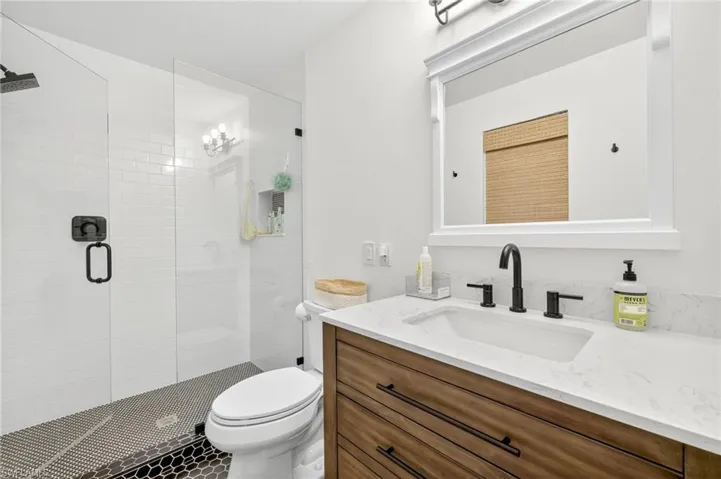 Full bath featuring a shower stall and vanity