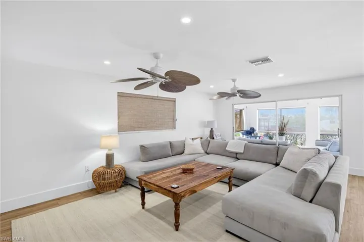 Living room with light wood-type flooring, recessed lighting, and a ceiling fan