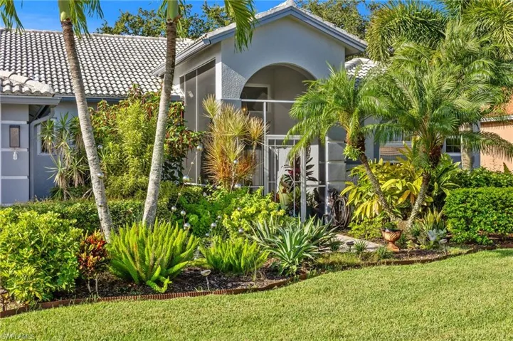 View of front of home with a front lawn, screened in front patio.