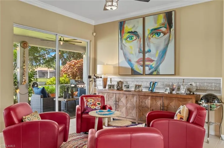 Sitting room featuring light tile flooring, ceiling fan, and ornamental molding.