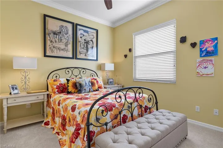 Bedroom with crown molding, light carpet, and ceiling fan.