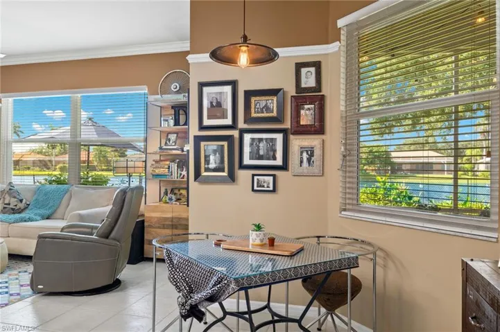 Dining area with light tile patterned flooring and crown molding.