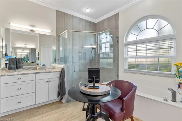 Bathroom featuring vanity, shower with separate bathtub, hardwood / wood-style flooring, and ornamental molding.