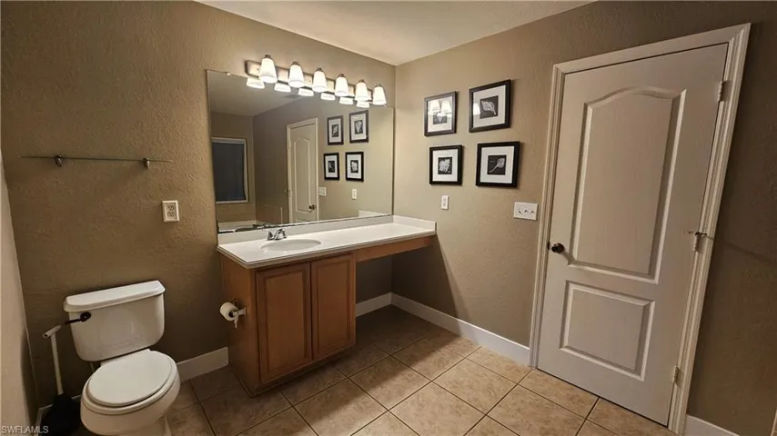 Bathroom featuring toilet, vanity, and tile patterned floors