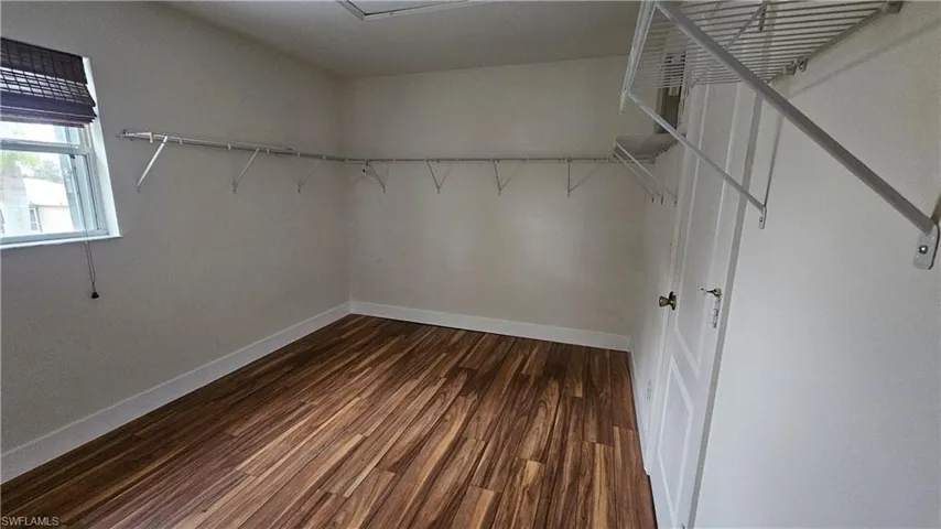 Spacious closet with dark hardwood / wood-style flooring