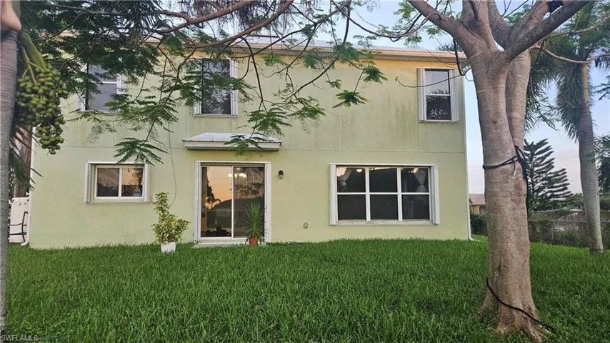 Rear view of property with a lawn