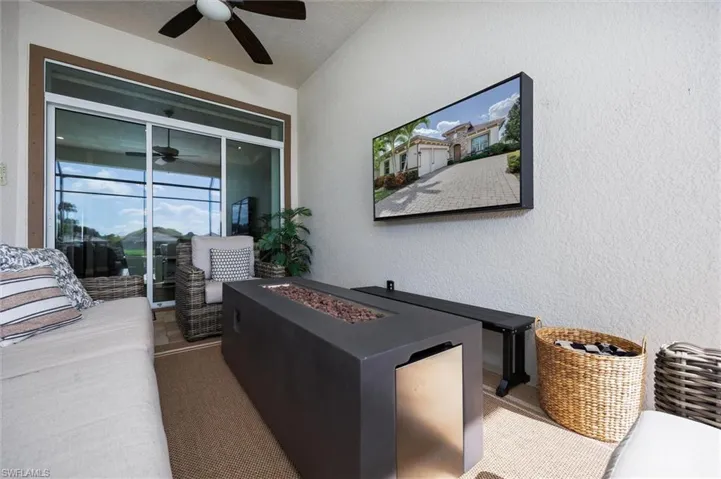 Covered outdoor lanai with textured walls, ceiling fan, and sliding glass doors