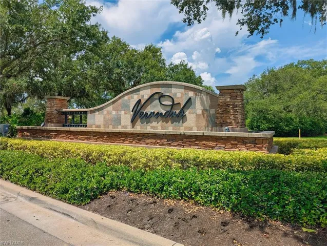 Stone-clad entryway signage featuring dimensional lettering and a decorative stone base