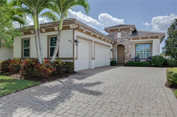Exterior featuring a stone facade, tile roofing, and a two-car garage