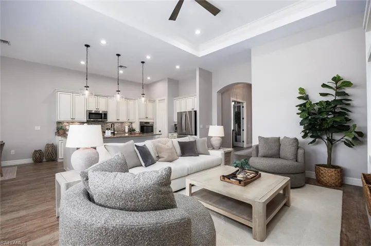 Open-concept living area featuring high tray ceilings and recessed lighting