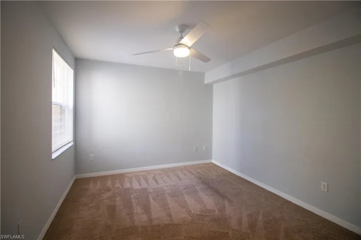 Unfurnished room with ceiling fan and carpet flooring