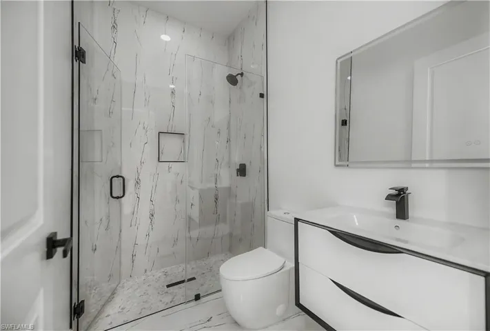 Walk-in shower with clear glass enclosure and black hardware