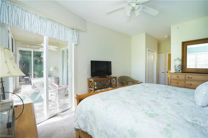 Carpeted bedroom featuring ceiling fan, a closet, and access to exterior