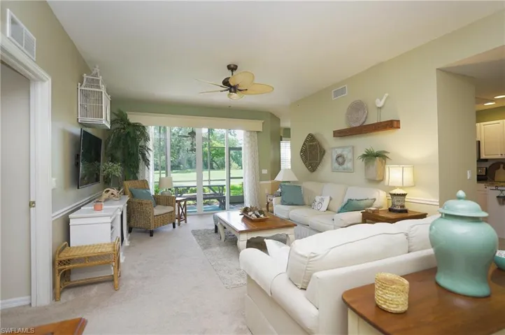 Living room with light carpet and ceiling fan