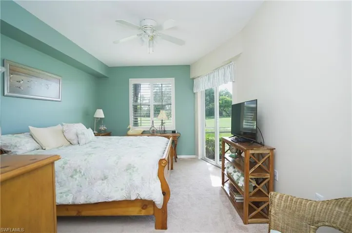 Carpeted bedroom featuring ceiling fan and access to outside