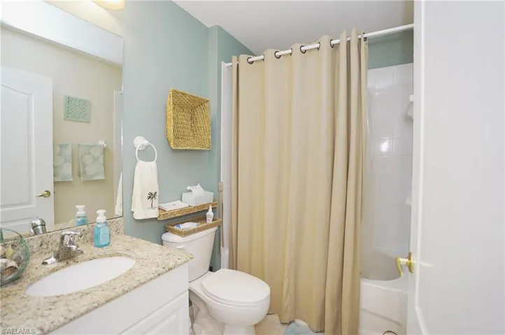 Full bathroom with shower / tub combo with curtain, vanity, and toilet