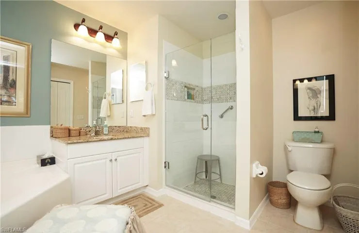 Full bathroom with tile patterned floors, vanity, toilet, and shower with separate bathtub